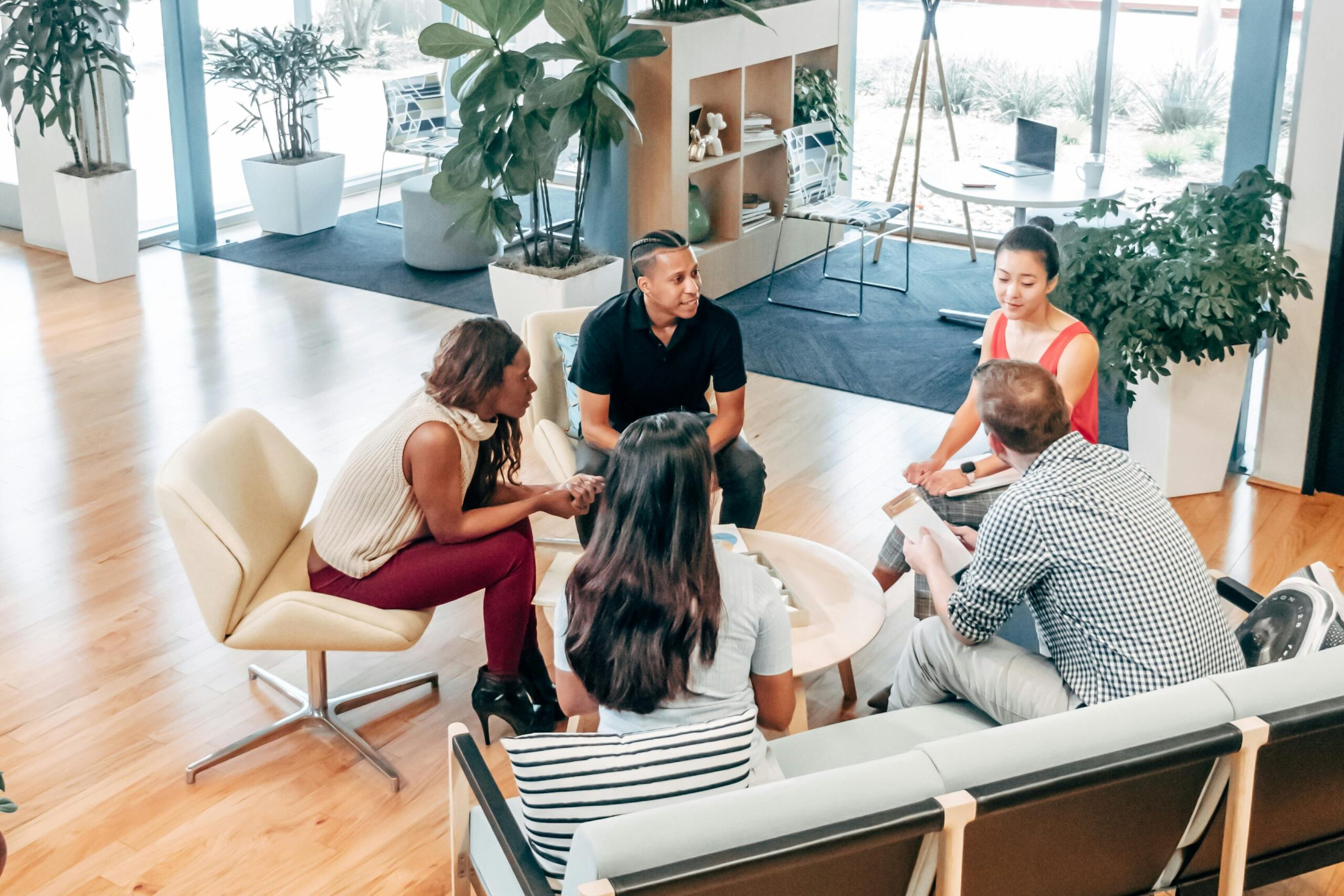 A diverse team in a modern office collaborating around a small table.