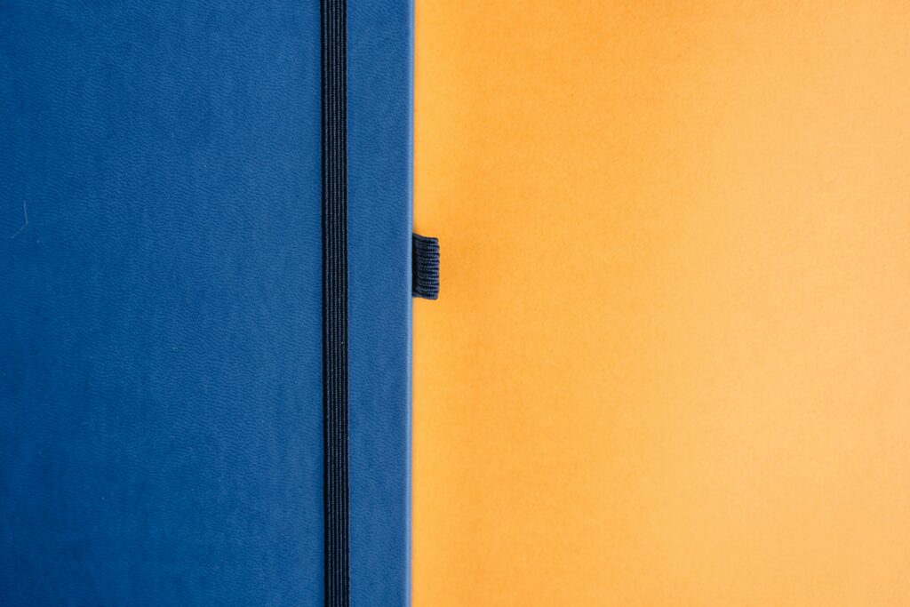 pexels-photo-7718665-7718665 A minimalist design featuring a blue notebook against a bright yellow backdrop.